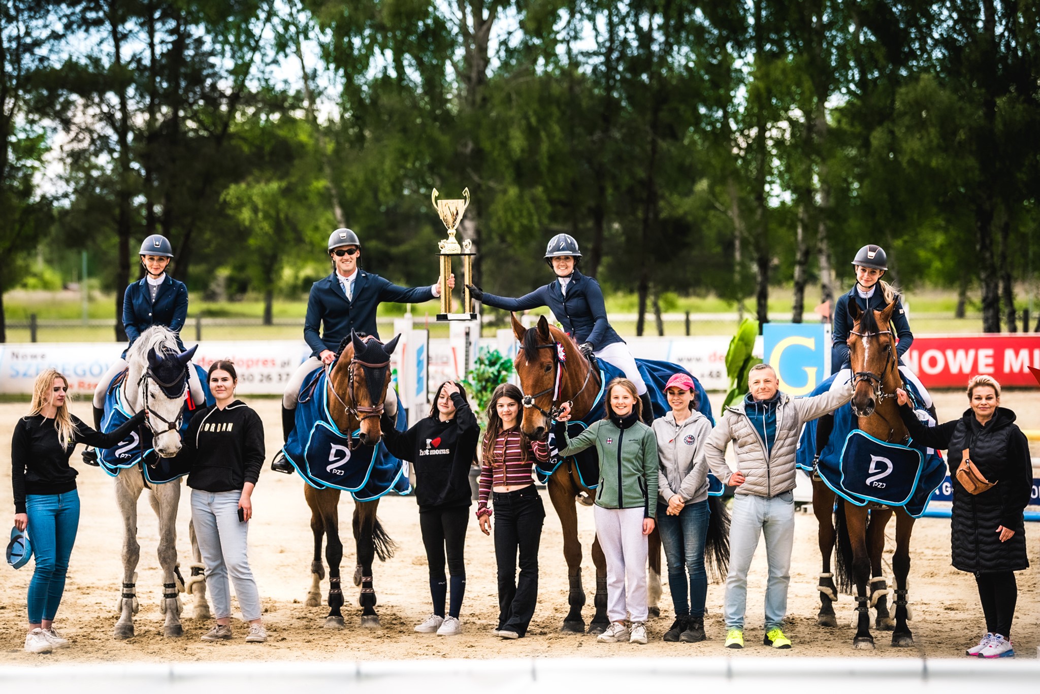 Zawodnicy z pucharem w Stadninie Koni w Leśnej Woli